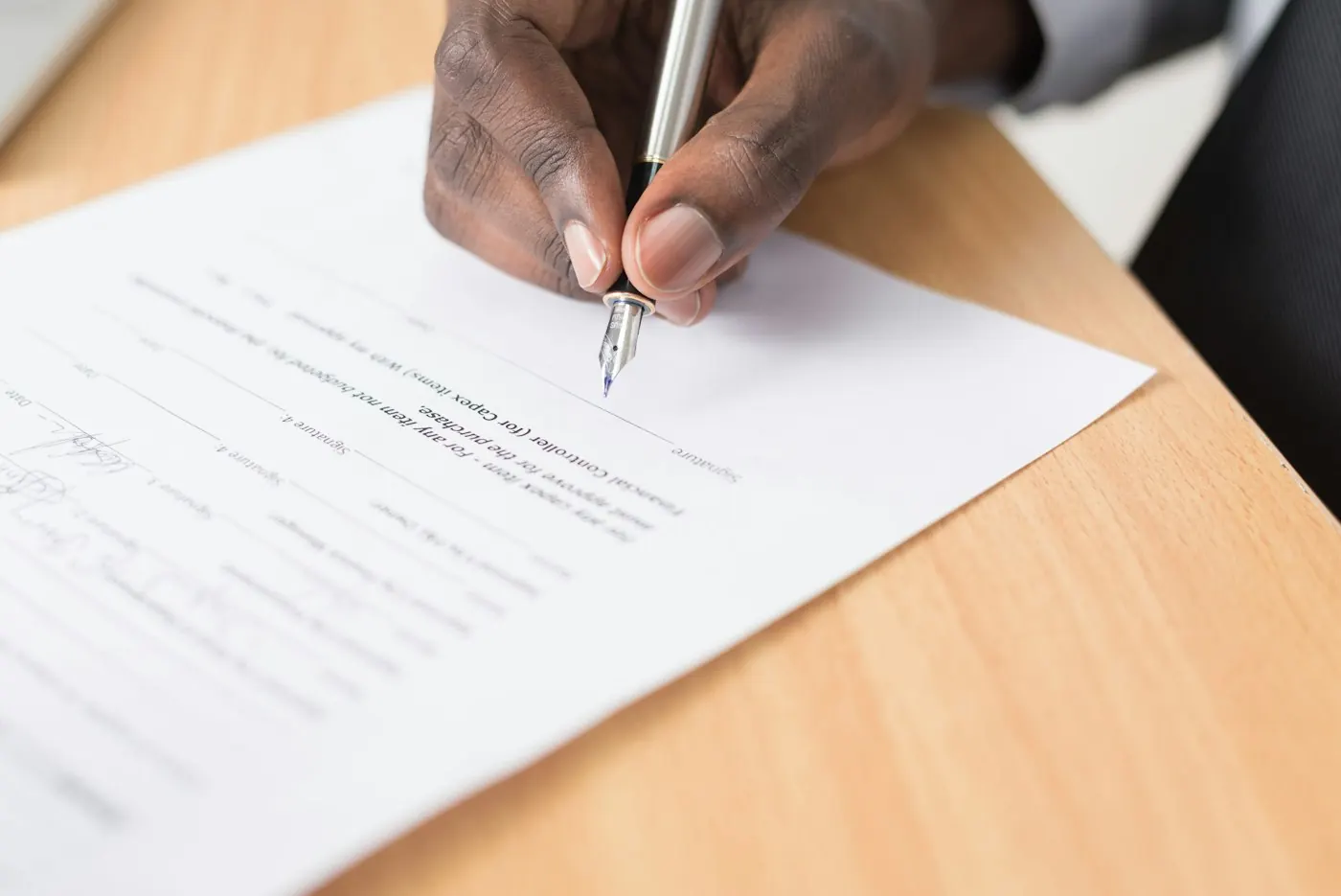 A hand signing a written agreement